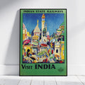A framed vintage-style travel poster leaning against a white wall on a light floor. The poster reads 'INDIAN STATE RAILWAYS' at the top and 'VISIT INDIA' at the bottom, with a colorful illustration of buildings, people, and umbrellas in India.