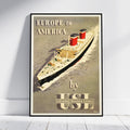 A framed vintage travel poster leaning against a white wall on a light floor. The poster shows a large ocean liner sailing on water with the text 'EUROPE to AMERICA by USI United States Lines'.