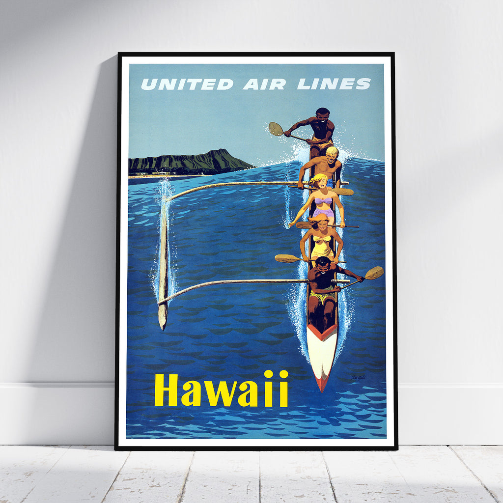 A framed vintage-style travel poster leaning against a white wall on a light floor. The poster shows four rowers in a double-hulled outrigger canoe on blue water, with a dark mountain island in the background and the text 'UNITED AIR LINES' at the top and 'Hawaii' at the bottom.
