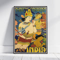 A framed vintage-style travel poster leaning against a white wall on a light floor. The poster features stylized figures in warm yellow, tan, red, and blue tones with large text reading 'AJJANTA FRESCOS CAVE TEMPLE' at the top and 'SEE INDIA' at the bottom.
