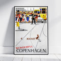 A framed vintage-style travel poster leaning against a white wall on a light floor. The poster depicts a busy Copenhagen street scene with a yellow tram, pedestrians, and a duck family, with the text 'WONDERFUL COPENHAGEN' at the bottom.