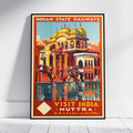 A vintage-style travel poster for Indian State Railways, featuring a colorful illustration of a domed palace and people by Muttra, India. The poster is displayed leaning against a white wall on a light wooden floor.
