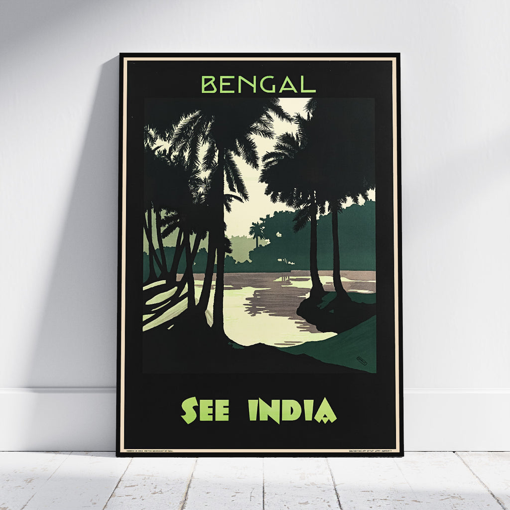 A framed travel poster leaning against a white wall on a light wood floor. The poster features a stylized illustration of palm trees and a shoreline with the text 'BENGAL' at the top and 'SEE INDIA' at the bottom in lime green.