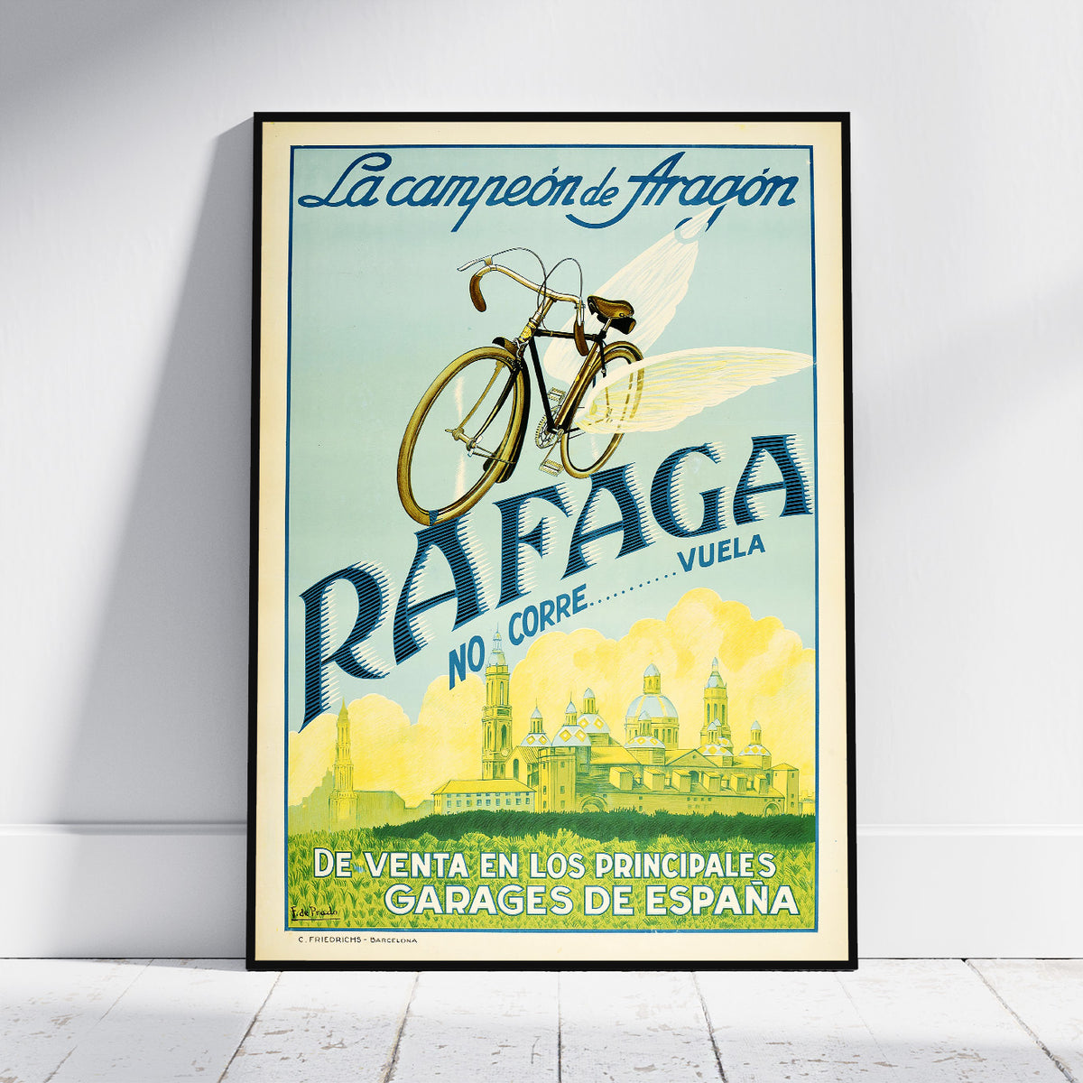 A framed vintage-style travel poster leaning against a white wall on a light floor. The poster features a bicycle with wings, the text 'La campeona de Aragón', 'RAFAGA NO CORRE.