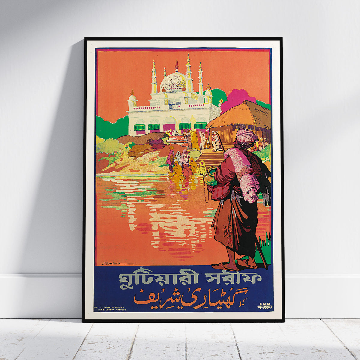 A framed vintage-style travel poster leaning against a white wall on a light floor. The poster depicts a colorful scene with a large white domed building, figures near water, and bold text at the bottom in Bengali and English.