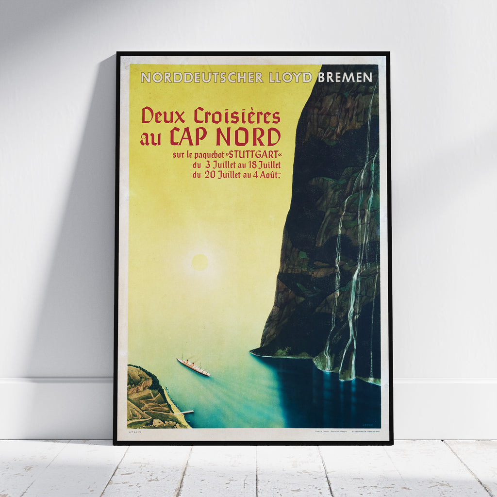 A framed vintage travel poster for Lloyd Bremen's 'Deux Croisières au Cap Nord' ship journey, leaning against a white wall on a light wood floor.