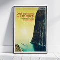 A framed vintage travel poster for Lloyd Bremen's 'Deux Croisières au Cap Nord' ship journey, leaning against a white wall on a light wood floor.