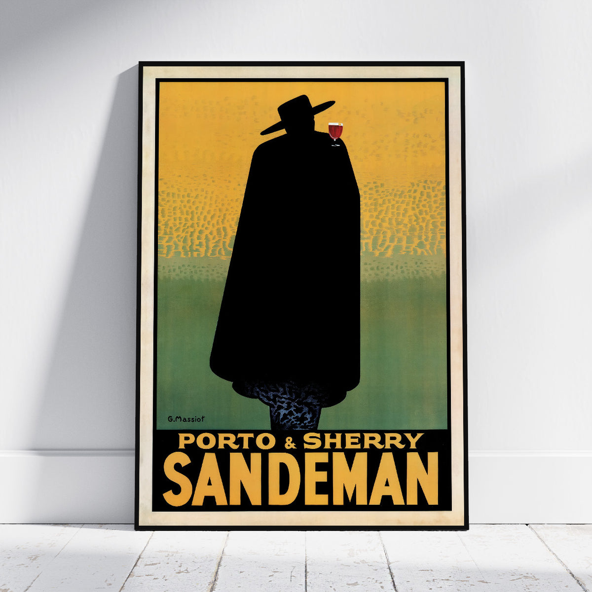 A framed vintage-style poster leaning against a white wall on a light floor. The poster shows a black silhouette of a cloaked figure wearing a hat and holding a red glass, with yellow-to-green background and the text 'PORTO & SHERRY SANDEMAN'.
