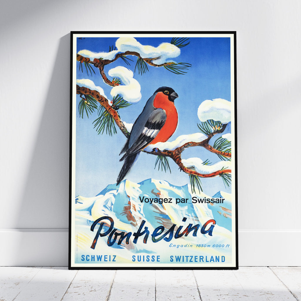A framed vintage-style travel poster leaning against a white wall on a light floor. The artwork shows a red-breasted bird perched on a snow-covered pine branch against a blue sky, with the text 'Voyagez par Swissair Pontresina' and 'Schweiz Suisse Switzerland' at the bottom.