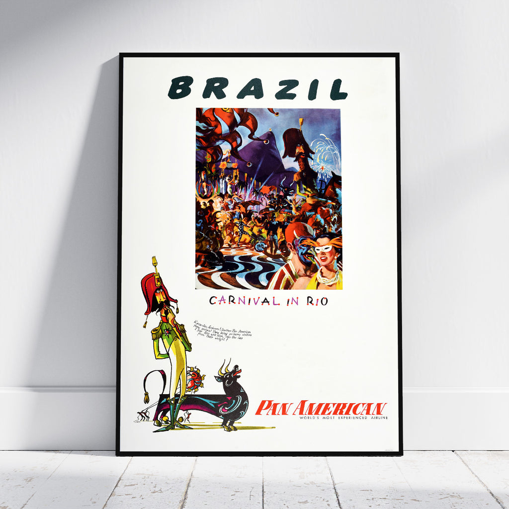 A framed vintage-style travel poster leaning against a white wall on a light wood floor. The poster reads "BRAZIL" at the top and "CARNIVAL IN RIO" below a colorful carnival scene, with "PAN AMERICAN" in red at the bottom.