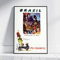 A framed vintage-style travel poster leaning against a white wall on a light wood floor. The poster reads "BRAZIL" at the top and "CARNIVAL IN RIO" below a colorful carnival scene, with "PAN AMERICAN" in red at the bottom.