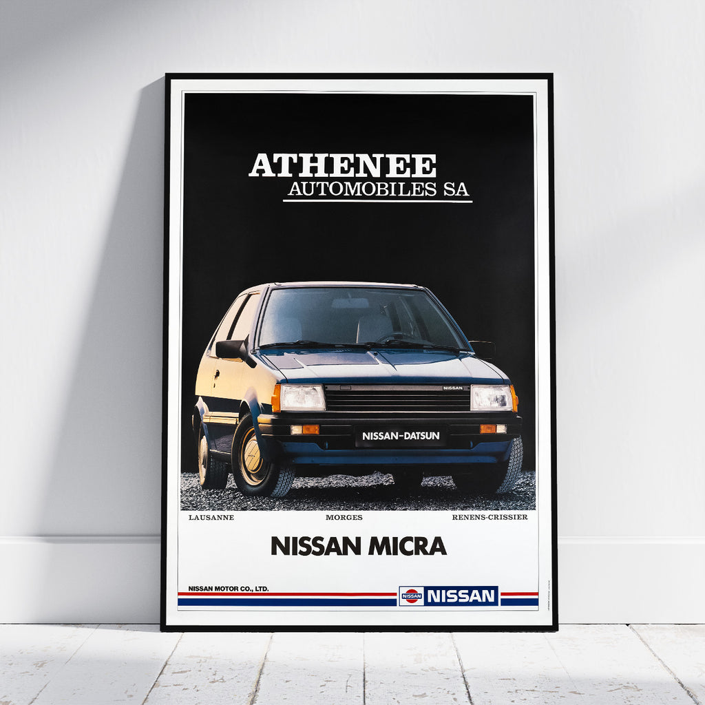 A framed vintage-style automotive poster leaning against a white wall on a light floor. The poster features a black background with a front-facing Nissan Micra car and the text 'ATHENEE AUTOMOBILES SA' at the top and 'NISSAN MICRA' at the bottom, with the Nissan logo visible.