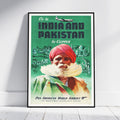 A framed vintage travel poster leaning against a white wall on a light wood floor. The poster features a green background with the text 'Fly to INDIA AND PAKISTAN by Clipper' and an illustration of a man in a red turban with a white beard, plus Pan American World Airways branding at the bottom.