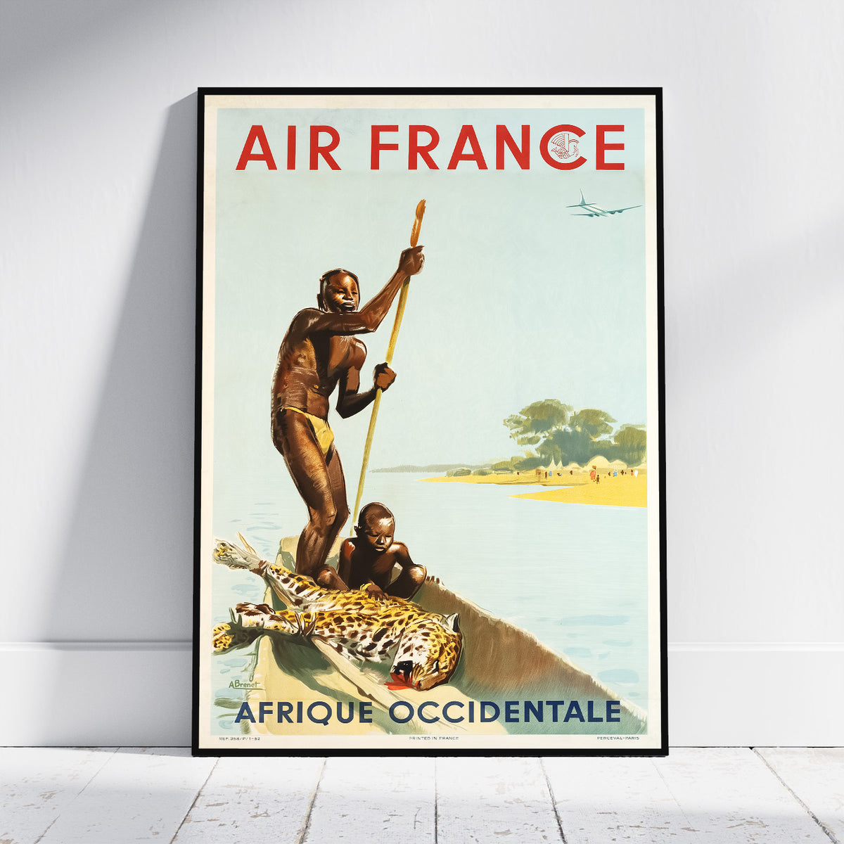 A framed vintage-style Air France travel poster leaning against a white wall on a light floor. The poster shows two people in a boat with a leopard on board, with the text 'AIR FRANCE' at the top and 'AFRIQUE OCCIDENTALE' at the bottom.
