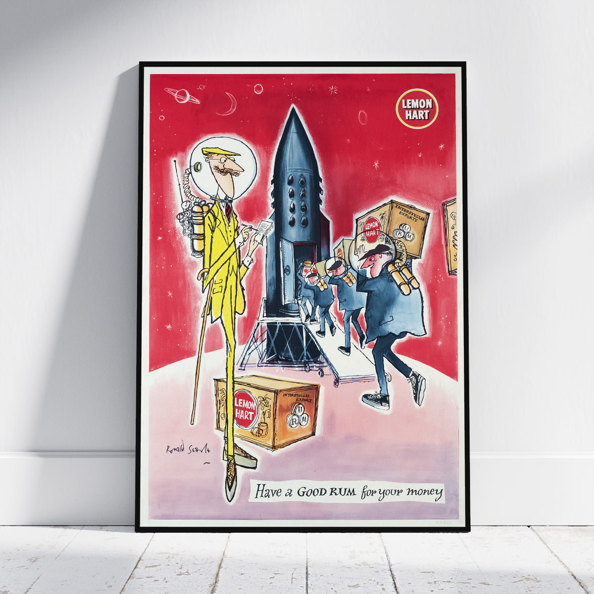 A framed cartoon art print leaning against a white wall on a light wood floor. The print features a red outer-space background with a tall rocket ship, a giant figure in a yellow suit, and several smaller figures carrying boxes labeled 'LEMON PART'.