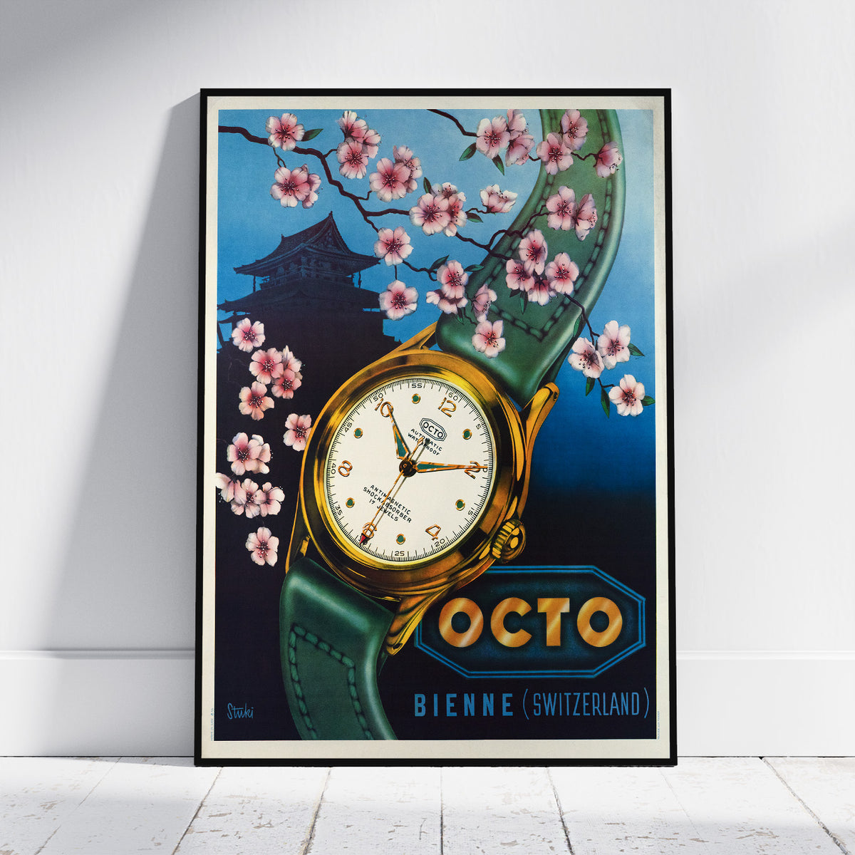 A framed vintage-style watch poster leaning against a white wall on a light wood floor. The artwork shows a gold-tone wristwatch with a green strap, pink cherry blossoms, a dark pagoda silhouette, and the text 'OCTO BIENNE (SWITZERLAND)'.