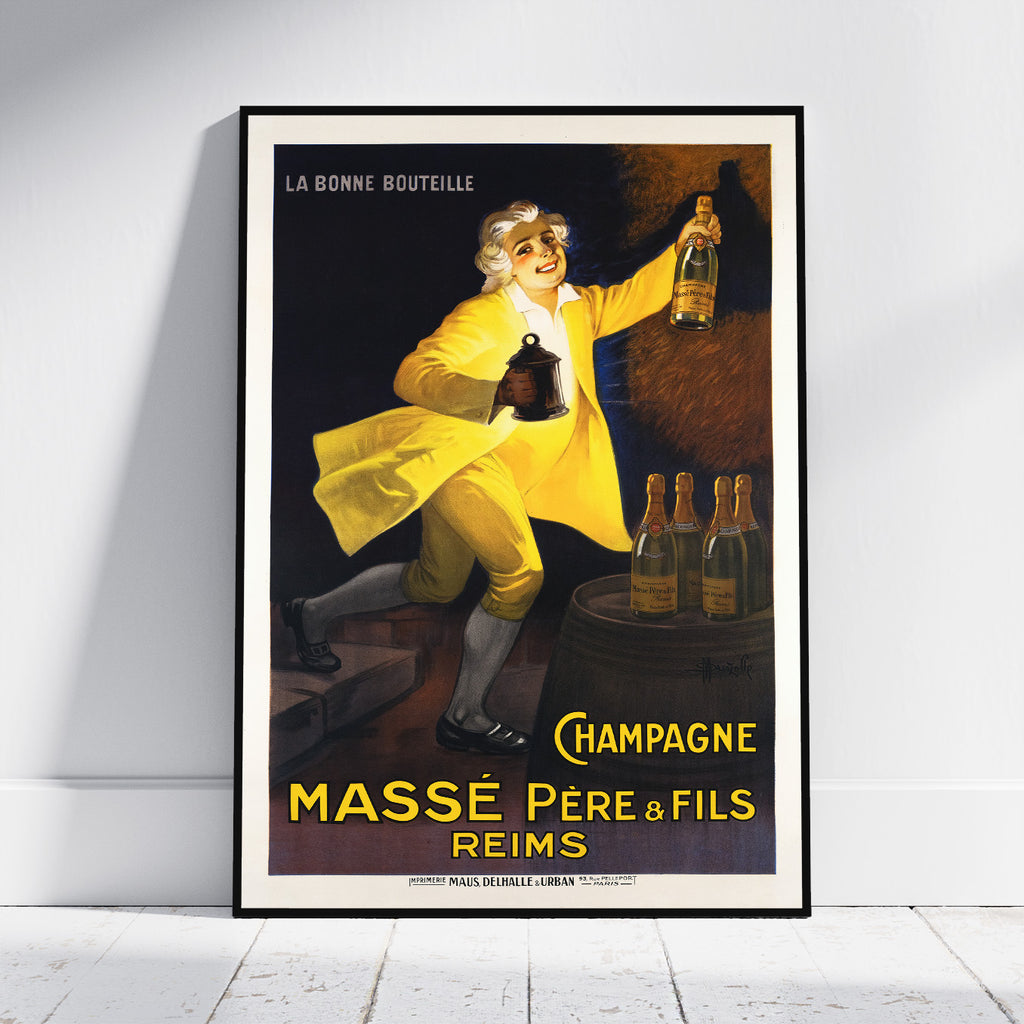 A framed vintage-style champagne poster leaning against a white wall on a light wood floor. The poster shows a man in a bright yellow outfit holding a bottle, with the text 'LA BONNE BOUTEILLE' at the top and 'CHAMPAGNE MASSÉ PÈRE & FILS REIMS' at the bottom.