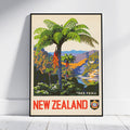 A framed vintage-style New Zealand travel poster leaning against a white wall on a light floor. The artwork shows a large green tree fern, colorful mountains, and the words “NEW ZEALAND” and “TREE FERN” in bold colors.