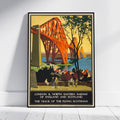 A framed vintage travel poster of the Scottish Borders Railway bridge over the River Tyne, leaning against a white wall on a light wood floor.