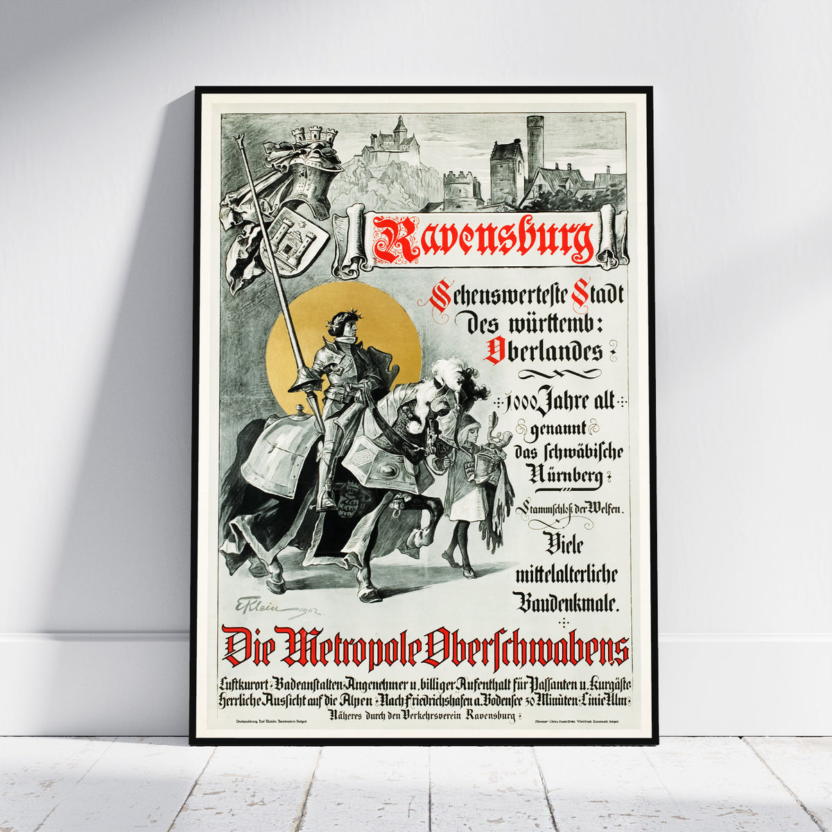 A framed vintage-style poster leaning against a white wall on a light wood floor. The poster features an illustrated medieval knight in armor, a castle skyline, and red and black text reading 'Ravensburg' and 'Die Metropole Obernauls'.
