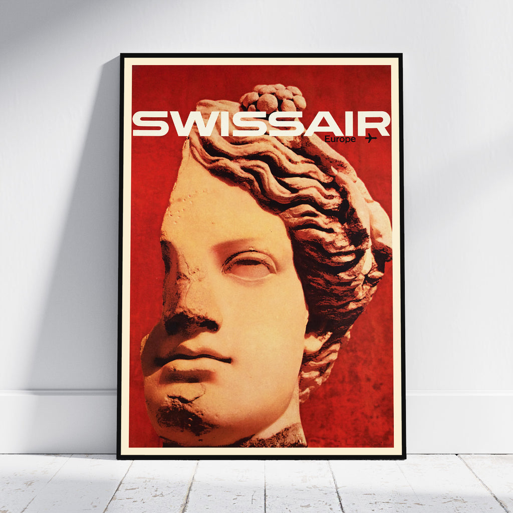 A framed poster leaning against a white wall on a light floor. The poster features a stylized classical bust portrait in warm beige tones over a vivid red background, with the word 'SWISSAIR' in large white letters at the top.