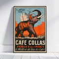A vintage-style illustrated poster for Café Collas leaning against a white wall on a light wood floor. The artwork shows an elephant carrying boxes labeled Café Collas, with large text reading 'CAFÉ COLLAS' and 'PÉRLES DES INDES' in orange, cream, black, and blue tones.