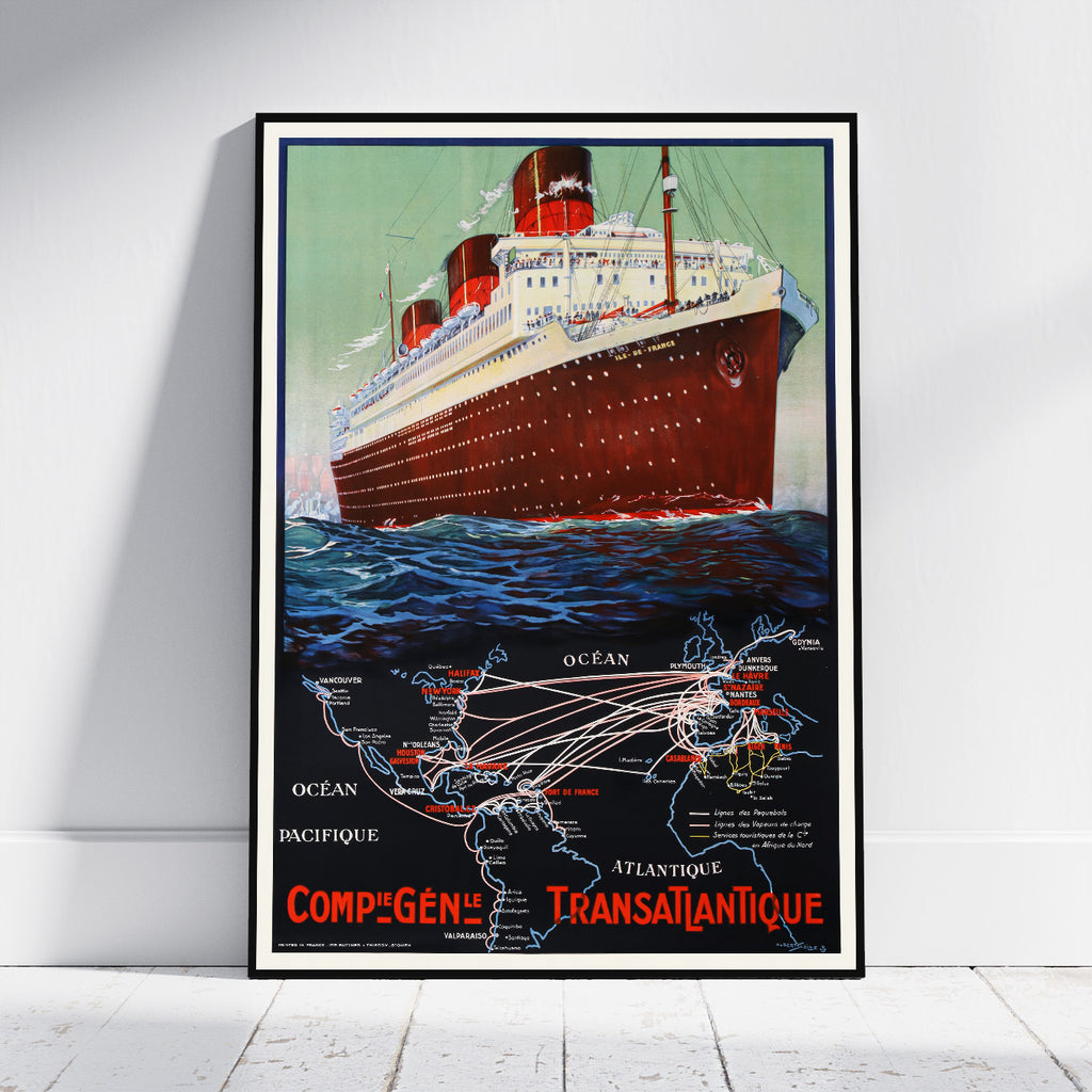 A framed vintage travel poster of the Compagnie Transatlantique ocean liner, leaning against a white wall on a light wood floor.