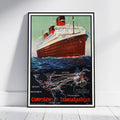 A framed vintage travel poster of the Compagnie Transatlantique ocean liner, leaning against a white wall on a light wood floor.
