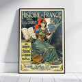 A framed vintage French book cover poster titled 'Histoire de France' by Victor Duruy, leaning against a white wall on a light wood floor. The poster features an illustrated seated woman in ornate blue and gold clothing with a red hat, holding a book and a flag, with decorative text and a yellow publisher box.