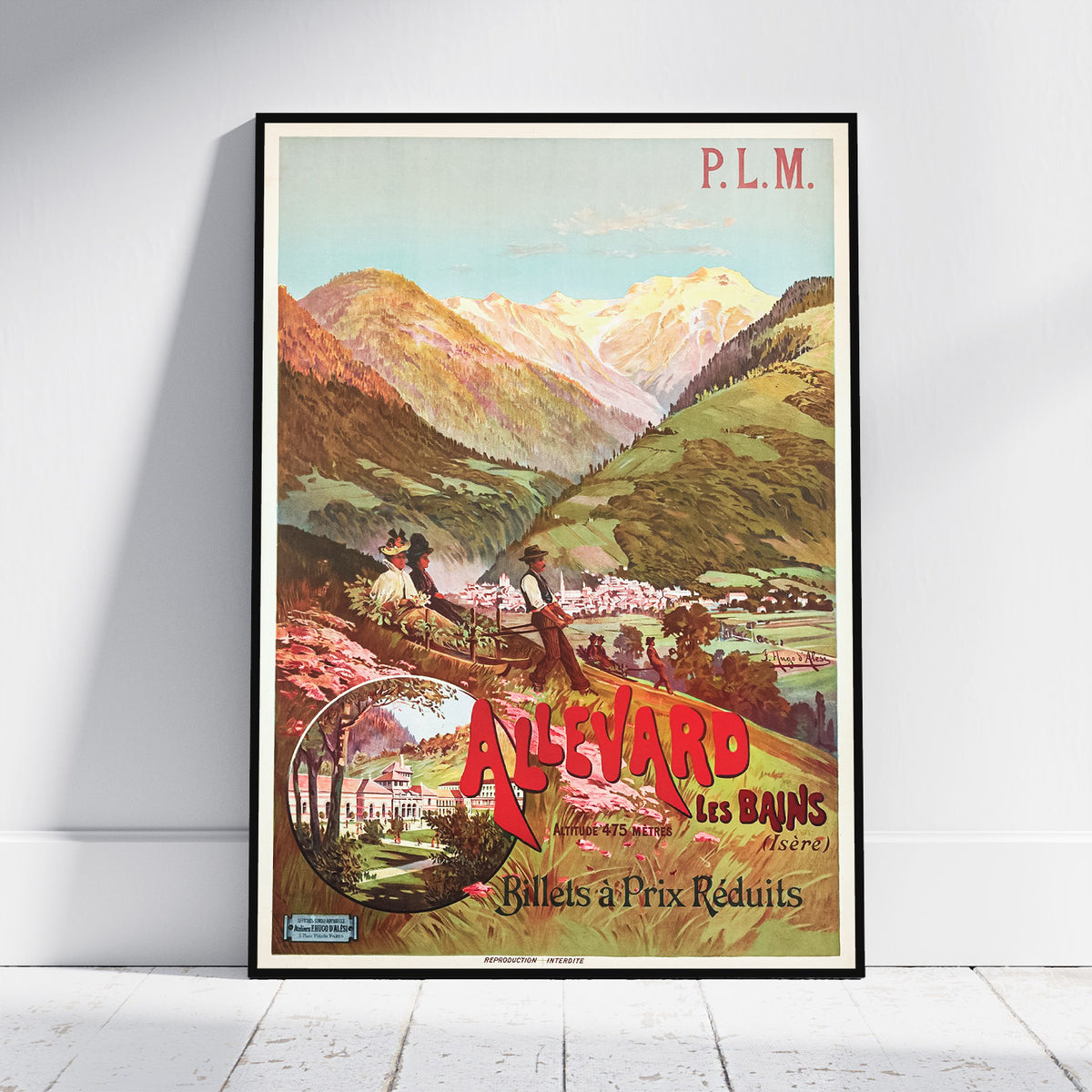 A framed vintage travel poster for 'Allevard Les Bains' leaning against a white wall on a light wood floor. The poster features a colorful illustration of a mountain valley with a gondola carrying passengers, and bold red and yellow text.