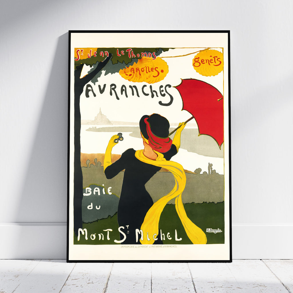 A framed vintage-style travel poster leaning against a white wall on a light wood floor. The poster features an Art Deco illustration of a woman in a black dress and red hat holding a red umbrella, with a yellow scarf, green landscape, and French text including 'Avranches' and 'Mont Saint-Michel'.