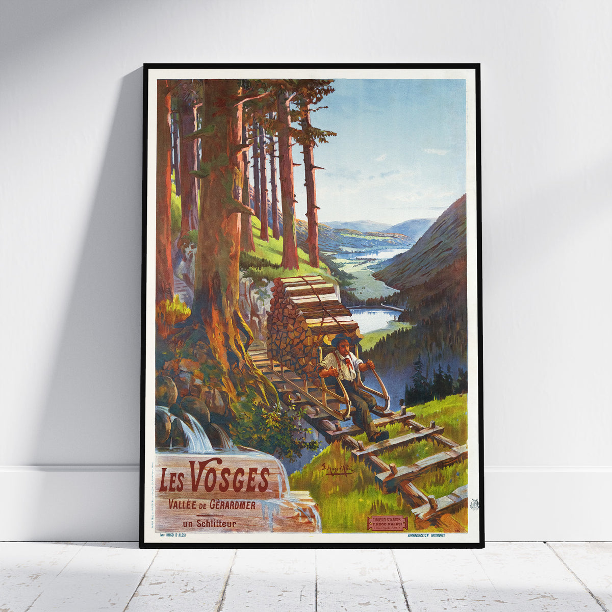 A framed vintage-style travel poster leaning against a white wall on a light wood floor. The artwork depicts a scenic mountain valley with tall trees, wooden stairs, a waterfall, and a person sitting on the steps.