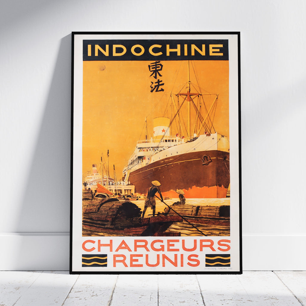 A framed vintage-style travel poster leaning against a white wall on a light floor. The poster reads "INDOCHINE" at the top and "CHARGEURS REUNIS" at the bottom, with an illustration of a large ship at a harbor in warm orange, yellow, and brown tones.