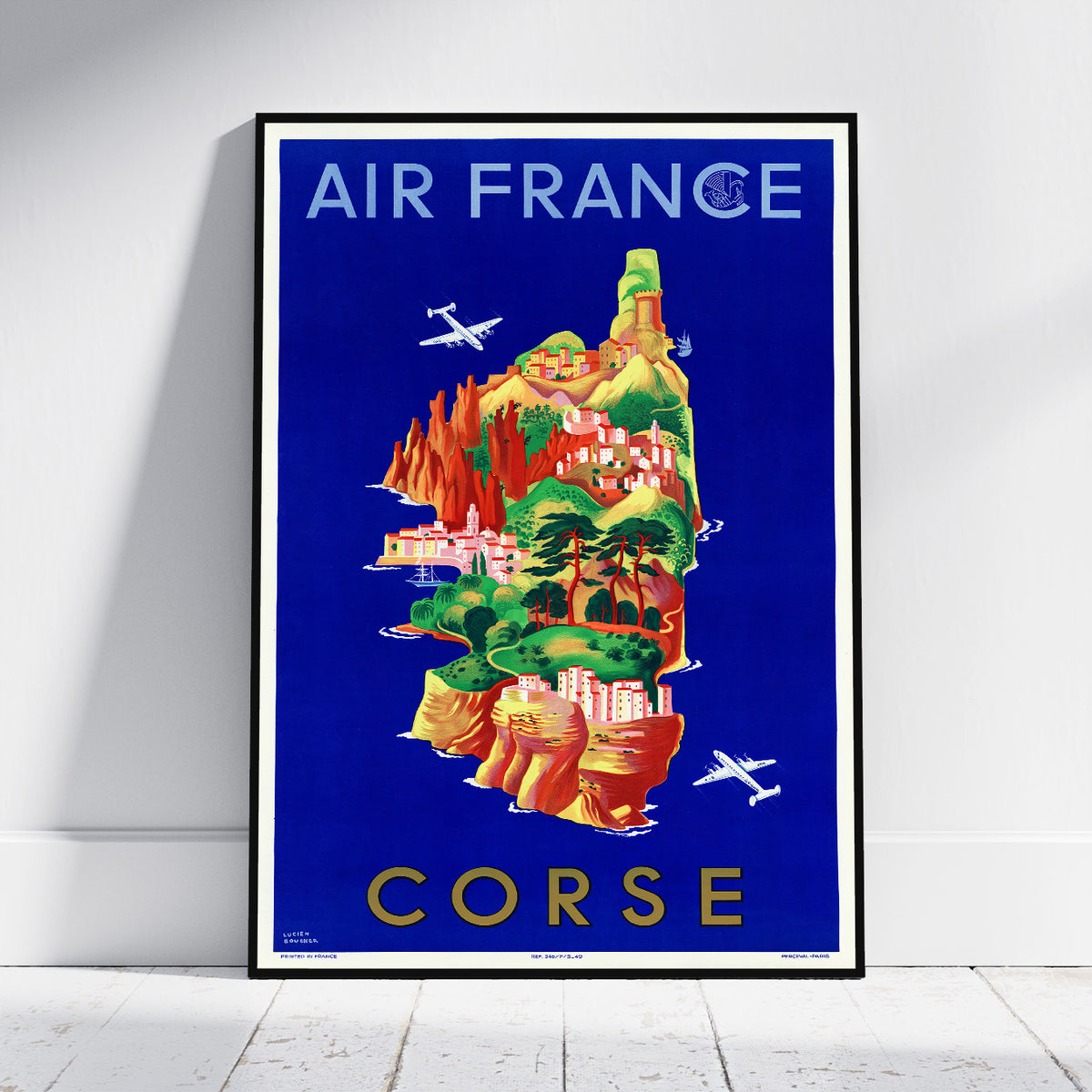 A framed vintage-style Air France poster featuring an illustrated island labeled CORSE, leaning against a white wall on a light floor.