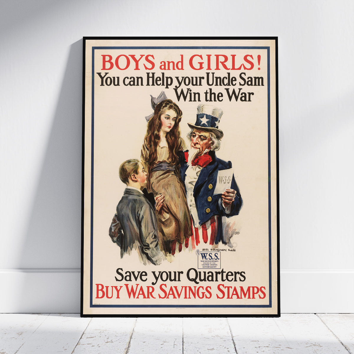 A framed vintage-style poster leaning against a white wall on a light floor. The poster reads “BOYS and GIRLS! You can Help your Uncle Sam Win the War Save your Quarters BUY WAR SAVINGS STAMPS” and shows an illustrated Uncle Sam, a woman, and a boy.