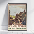 A framed vintage-style New York travel poster leaning against a white wall on a light floor. The poster shows an aerial view of the city skyline and water with text reading 'NEW YORK THE UPPER BAY FROM LOWER MANHATTAN' and 'NEW YORK CENTRAL SYSTEM'.