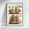 A framed vintage nautical art print featuring detailed illustrations of historical sailing ships on an off-white background, leaning against a white wall on a light wood floor.