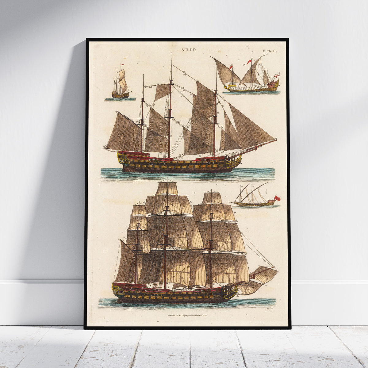 A framed vintage nautical art print featuring detailed illustrations of historical sailing ships on an off-white background, leaning against a white wall on a light wood floor.