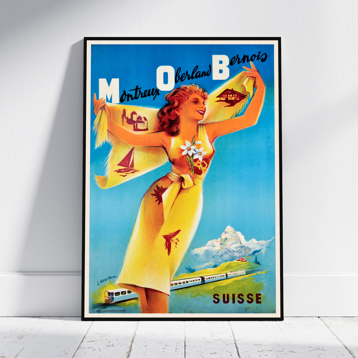 A framed vintage travel poster leaning against a white wall on a light wood floor. The poster features a woman in a yellow dress holding a scarf with Swiss-themed illustrations, including a train and mountains, and the text 'MOUBERTS Berne-nois' and 'SUISSE'.