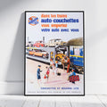A framed vintage French travel poster leaning against a white wall on a light floor. The poster features retro illustration of trains, cars, passengers, and French text reading 'dans les trains auto-couchettes vous emportez votre auto avec vous' and 'COUCHETTES WAGONS-LITS'.