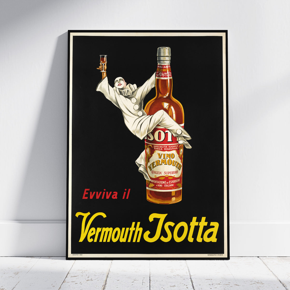 A framed vintage-style poster leaning against a white wall on a light wood floor. The poster features a black background with a large amber bottle labeled Vermouth Isotta and a white-clad figure reaching upward, with red and yellow text reading 'Evviva il Vermouth Isotta.