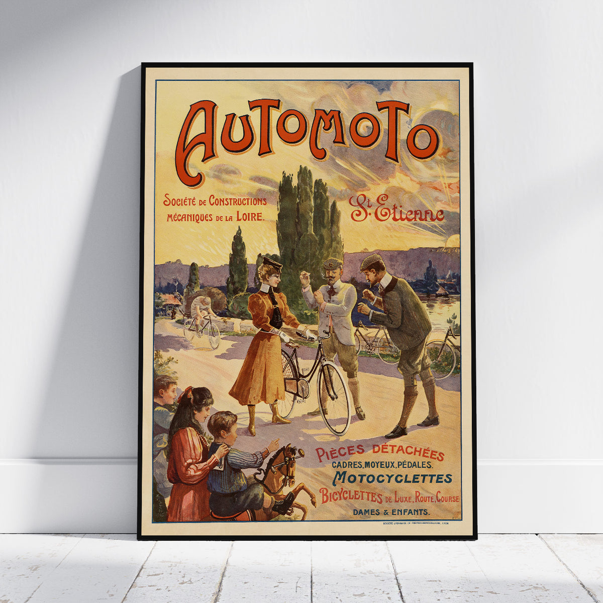 A framed vintage-style poster reading 'Automoto' with an illustrated outdoor scene of people with bicycles, leaning against a white wall on a light floor.
