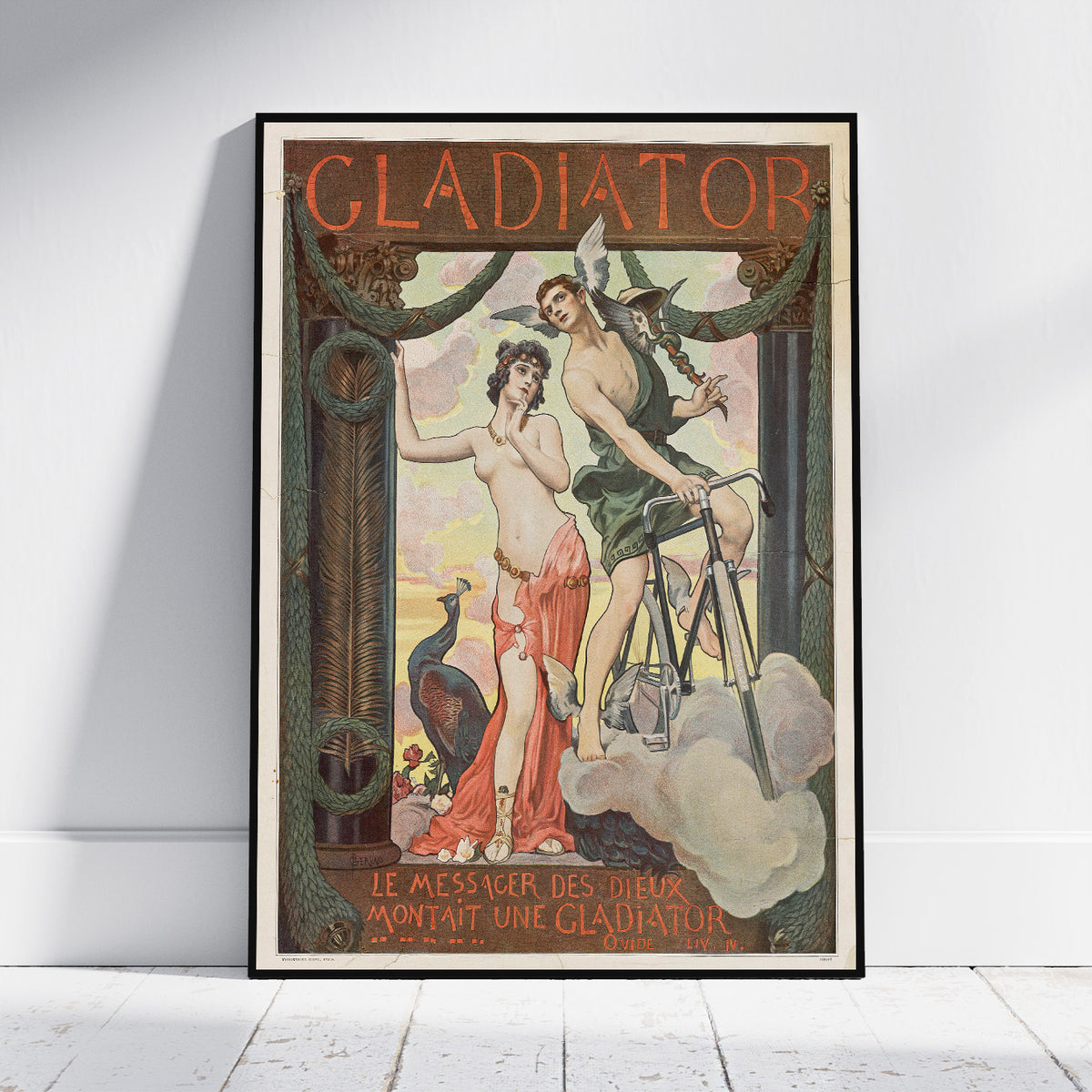 A framed vintage Art Nouveau poster titled 'GLADIATOR' leaning against a white wall on a light wood floor. The poster features an ornate illustration with two classical figures, a peacock, clouds, and decorative typography.