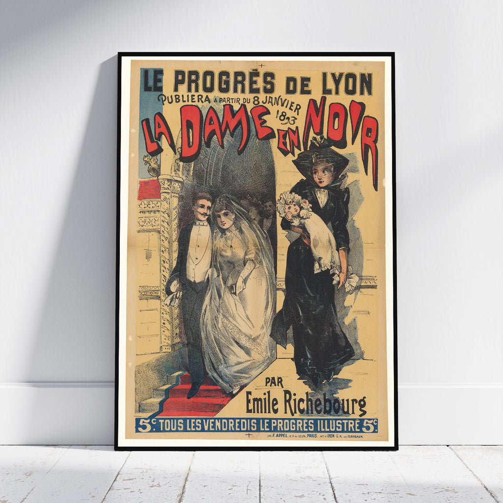 A framed vintage theatrical poster leaning against a white wall on a light wood floor. The poster features illustrated figures in formal 19th-century clothing with large red title text reading 'La Dame en Noir' and additional French text at the top and bottom.