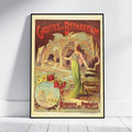 A framed vintage travel poster for 'Grottes de Bétharram' leaning against a white wall on a light wood floor. The poster features an illustration of a woman in a green dress in a cave, with red lettering and a cream border.