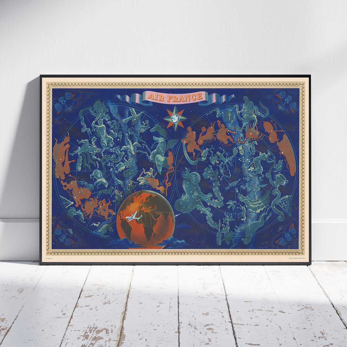 A framed art print leaning against a white wall on a white wooden floor. The print features a vintage-style map of France and surrounding countries in teal and orange on a dark blue background, with a globe graphic at the bottom and a banner reading 'AIR FRANCE' at the top.