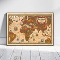A framed vintage-style world map poster leaning against a white wall on a white wood floor. The map features illustrated continents in warm brown and beige tones with decorative sea routes, ships, compass roses, and a decorative title cartouche reading 'AIR FRANCE'.